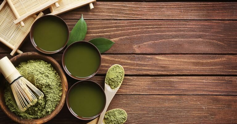 Top view of traditional matcha tea setup with utensils on a wooden table, showcasing a blend of culture and flavor.