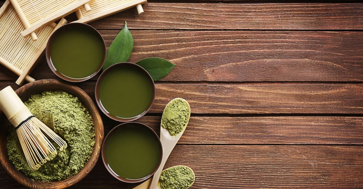 Top view of traditional matcha tea setup with utensils on a wooden table, showcasing a blend of culture and flavor.