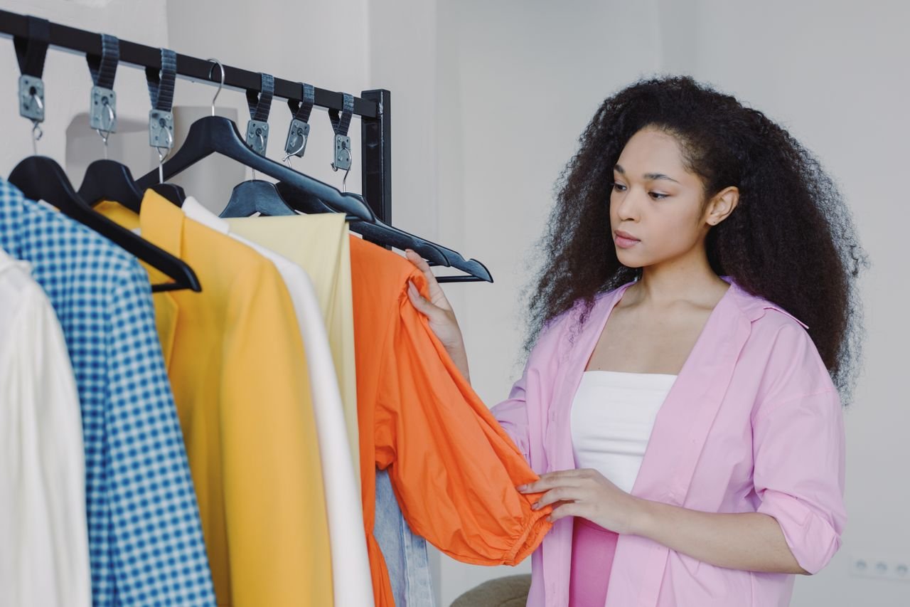 Woman browsing colorful clothes in a boutique, exploring fashion options.